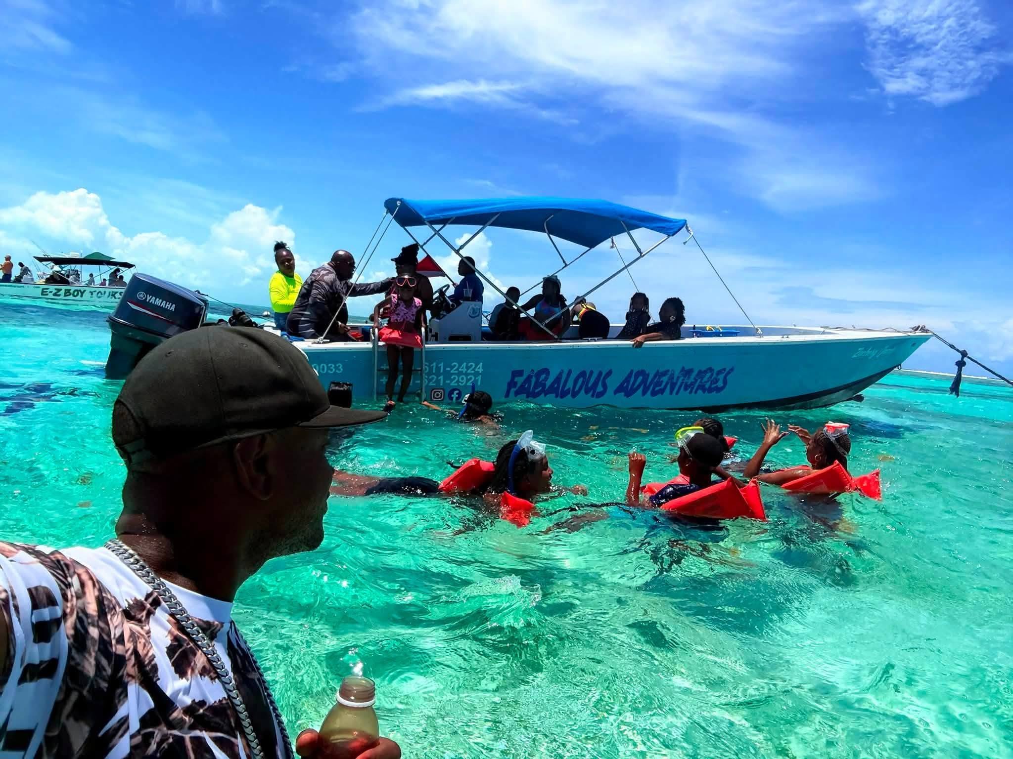 Snorkelers in turquoise water beside the Fabulous Adventures boat